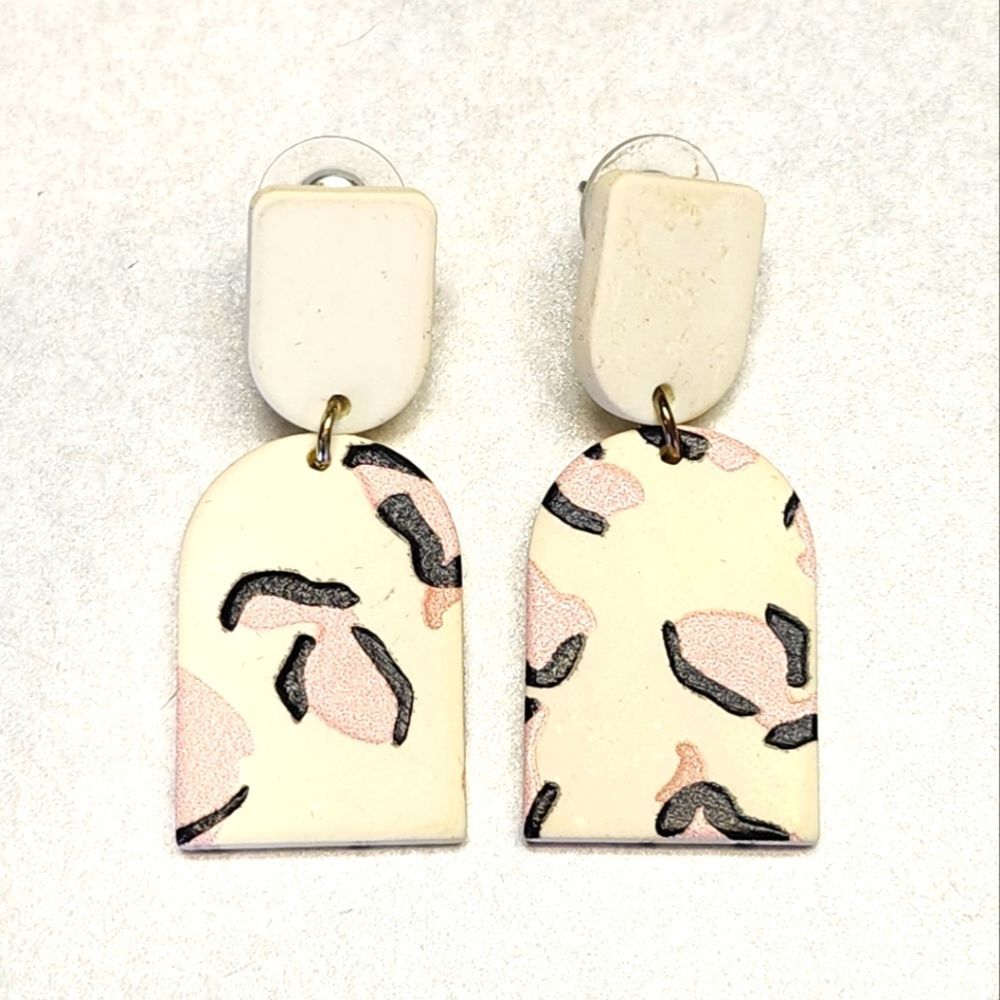 Costume jewelry off white dangle earrings with pink & black animal print